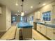 Kitchen with a view into the living room, featuring an island, white cabinets, and modern lighting at 60 Bennett Rd, Coats, NC 27521