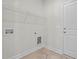 Clean laundry room with tile flooring, washer/dryer hookups, and shelving for storage at 60 Bennett Rd, Coats, NC 27521