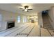 Bright living room featuring a fireplace, ceiling fan, staircase, and open floor plan to the kitchen at 60 Bennett Rd, Coats, NC 27521