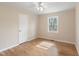 Cozy bedroom with hardwood floors, a ceiling fan, and a window offering natural light and a pleasant view at 320 Zollicoffer Ave, Henderson, NC 27536