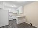 A bright kitchen featuring white cabinets, updated countertops, gray floors, and a white appliance at 320 Zollicoffer Ave, Henderson, NC 27536