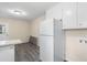 A bright kitchen featuring white cabinets, updated countertops, gray floors, and a white refrigerator at 320 Zollicoffer Ave, Henderson, NC 27536