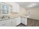 A bright kitchen featuring white cabinets, updated countertops, a sink, and natural light at 320 Zollicoffer Ave, Henderson, NC 27536