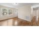 Bright living room with original hardwood floors, large windows, and neutral walls creates an airy and welcoming space at 320 Zollicoffer Ave, Henderson, NC 27536