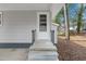 View of the front porch featuring black railings, gray stairs, and a white front door at 320 Zollicoffer Ave, Henderson, NC 27536