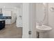 Modern bathroom with pedestal sink and lovely faucet plus view of kitchen with herringbone backsplash at 35 Accord Dr, Youngsville, NC 27596