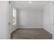 Minimalist bedroom with hardwood floors, crown molding, and a large window providing natural light at 35 Accord Dr, Youngsville, NC 27596