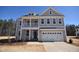 Charming two-story home featuring a welcoming front porch, a two-car garage, and classic architectural details at 35 Accord Dr, Youngsville, NC 27596
