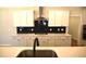 Stylish kitchen showcasing white cabinets, a striking dark backsplash, and a central island with modern fixtures at 35 Accord Dr, Youngsville, NC 27596