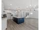 Open-concept kitchen with a navy island, quartz countertops, white cabinets, and an adjacent living area at 35 Accord Dr, Youngsville, NC 27596