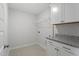 Well-lit laundry room with tile flooring, granite countertops, upper cabinets, and wire shelving at 35 Accord Dr, Youngsville, NC 27596