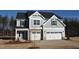 Beautiful two-story home with stone accents, gray siding, attached two-car garage, and professionally landscaped yard at 55 Accord Dr, Youngsville, NC 27596