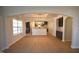 Open concept living area with hardwood floors, archway to kitchen, and large windows at 55 Accord Dr, Youngsville, NC 27596