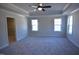 Large main bedroom with plush carpeting, ceiling fan, tray ceiling, and a walk-in closet at 55 Accord Dr, Youngsville, NC 27596
