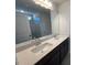 Bathroom with double sink vanity, stone countertop, large mirror, and view into shower stall at 55 Calabria Ct, Franklinton, NC 27525