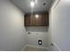 Laundry room features cabinets, tile floors, and utility connections at 55 Calabria Ct, Franklinton, NC 27525