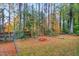 Backyard with mature trees and a fire pit on a beautiful fall day at 710 Spring Ln, Sanford, NC 27330