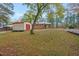 Exterior view of the backyard featuring a detached metal shed and a well maintained lawn at 710 Spring Ln, Sanford, NC 27330