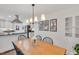 Bright dining room with a wood table set for six, modern lighting, and an open view to the kitchen at 710 Spring Ln, Sanford, NC 27330