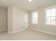 Bright bedroom featuring a large window, neutral walls, trim, and carpet at 112 Bear Wallow Forest Way, Wendell, NC 27591