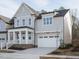 Beautiful light gray two-story home with a welcoming front porch and a spacious two-car garage at 112 Bear Wallow Forest Way, Wendell, NC 27591