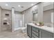 Well-lit bathroom featuring double sinks, framed mirror, a shower with glass door, and a linen closet at 1235 Schloss Rd, Louisburg, NC 27549