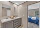 Bathroom featuring double sinks, gray cabinets, and a view into a bedroom with natural light at 1235 Schloss Rd, Louisburg, NC 27549
