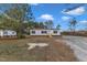 A comfortable, single-story home set on a sprawling lot with a gravel driveway and a green lawn at 1235 Schloss Rd, Louisburg, NC 27549