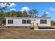 Single-story home with white siding, brick accents, and a wooden front porch at 1235 Schloss Rd, Louisburg, NC 27549