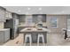 Gray kitchen with stainless steel appliances, an island with bar stool seating, and bright natural light at 1235 Schloss Rd, Louisburg, NC 27549