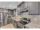 Spacious kitchen showcases stainless steel appliances, granite counters, gray cabinets, and a stylish range hood at 1235 Schloss Rd, Louisburg, NC 27549