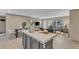 Open-concept floor plan with gray island, modern dining set, and cozy living room with natural light at 1235 Schloss Rd, Louisburg, NC 27549