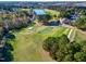 Scenic aerial view of a golf course with lush green fairways, pristine sand traps, and a tranquil lake in the background at 1509 Heritage Reserve Ct, Wake Forest, NC 27587