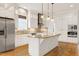Well-lit kitchen with a large center island, stainless appliances, and tile backsplash at 1509 Heritage Reserve Ct, Wake Forest, NC 27587