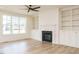 Bright living room featuring a fireplace, custom built-ins, and large windows at 201 Wash Hollow Dr, Wendell, NC 27591