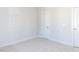 Bright bedroom with neutral carpet, white walls, and two white doors at 220 Big Bradley Dr, Wendell, NC 27591