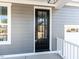 Close-up of the front door with glass panels, gray siding, and white trim at 220 Big Bradley Dr, Wendell, NC 27591