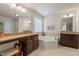 Serene bathroom featuring a soaking tub, dual vanities, and tiled flooring at 7124 Hinman Ln, Apex, NC 27539