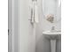 Bright bathroom featuring a pedestal sink with a chrome faucet and an oval mirror at 232 Big Barn Dr, Wendell, NC 27591