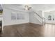 Spacious, unfurnished living room with hardwood floors and natural light showcasing the entryway and staircase at 232 Big Barn Dr, Wendell, NC 27591