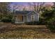 Gray house with small front porch, surrounded by trees and autumn leaves at 4505 Laymans Chapel Rd, Durham, NC 27704