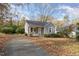 Small gray house with gravel driveway, surrounded by trees and leaves at 4505 Laymans Chapel Rd, Durham, NC 27704