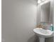 Well-lit powder room featuring a pedestal sink and decorative mirror at 821 Stackhurst Way, Wake Forest, NC 27587
