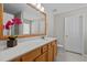 Bathroom features a vanity with a large mirror, white countertops and wood cabinets, along with a toilet at 821 Stackhurst Way, Wake Forest, NC 27587