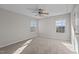 Bright bedroom featuring neutral walls, carpet flooring, a ceiling fan and two windows with lovely natural light at 821 Stackhurst Way, Wake Forest, NC 27587