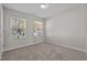 Clean bedroom with neutral walls, carpet flooring, and two windows providing natural light and views of the neighborhood at 821 Stackhurst Way, Wake Forest, NC 27587