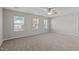 Large bedroom featuring neutral walls, carpet flooring, a ceiling fan, and three windows offering bright natural light at 821 Stackhurst Way, Wake Forest, NC 27587