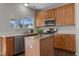 A kitchen island is the focus of this shot with wood cabinets and stainless steel appliances at 821 Stackhurst Way, Wake Forest, NC 27587