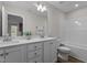 Bright bathroom with dual sinks, white cabinetry, and a bathtub with white tiled walls at 9184 Phoenix Ct, Middlesex, NC 27557
