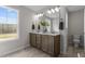 Bathroom featuring a double sink vanity with light countertops and warm wood cabinets at 9184 Phoenix Ct, Middlesex, NC 27557